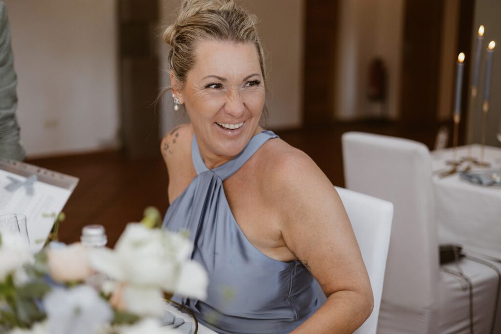 Eine hübsche frau in GrauBlauem kleid lach freundlich.